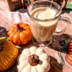 whipped pumpkin spice latte dalgona coffee with pumpkins around it
