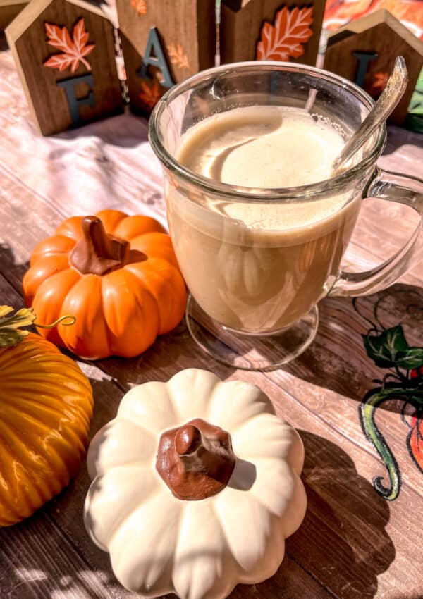 whipped pumpkin spice latte dalgona coffee with pumpkins around it