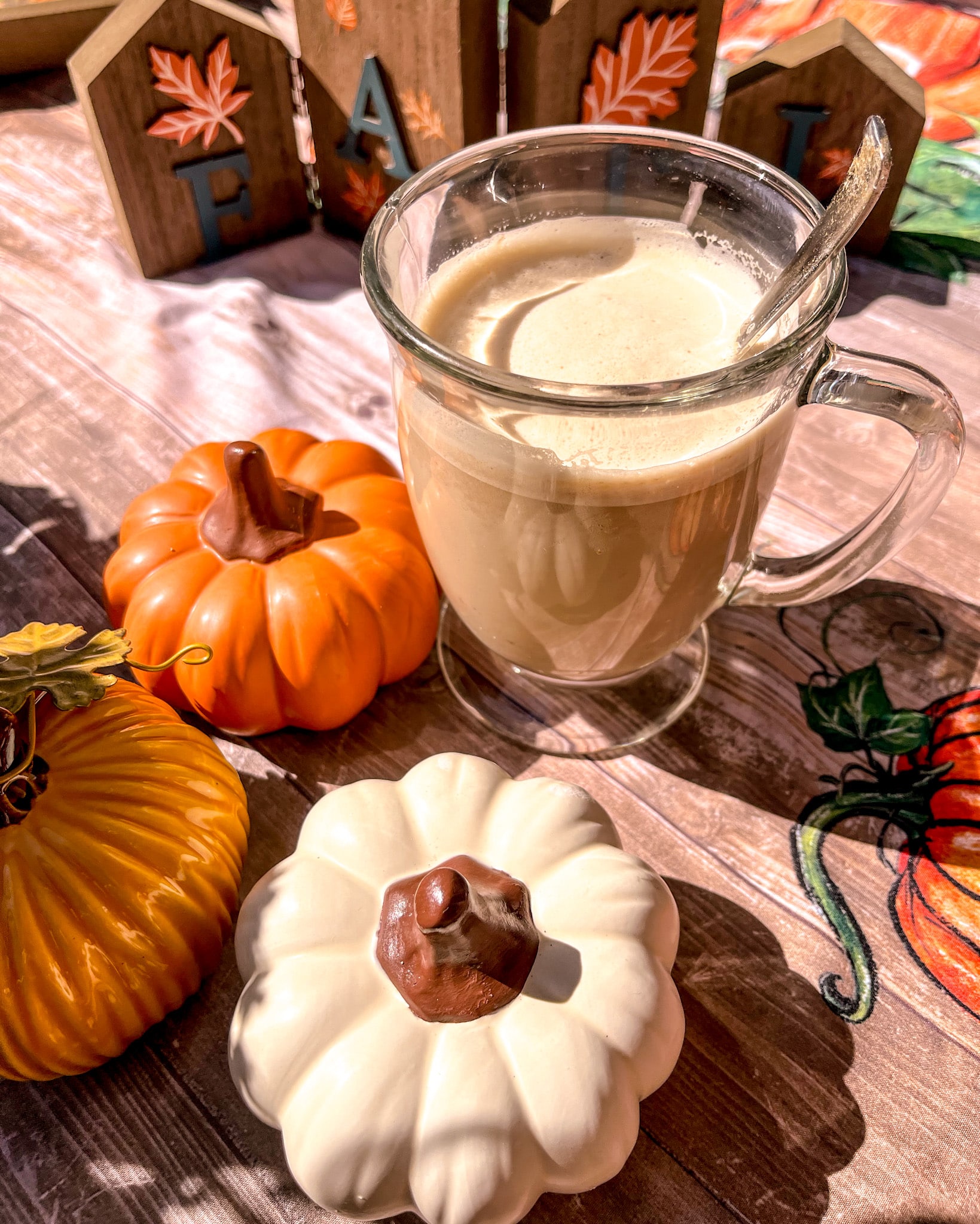 whipped pumpkin spice latte dalgona coffee with pumpkins around it