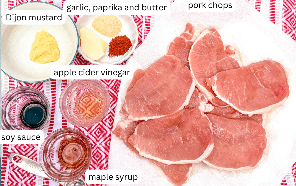 Ingredients for maple glazed pork chops including maple syrup, soy sauce, Dijon mustard, and pork chops.
