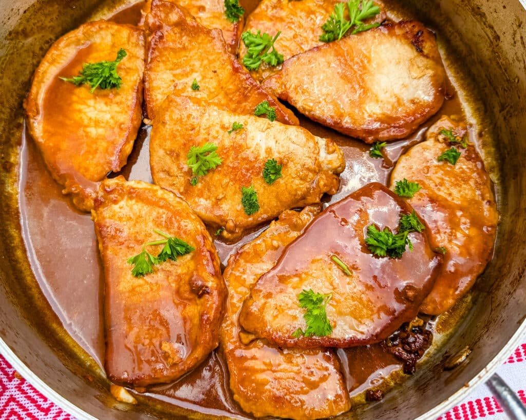 maple glazed pork chops in a pan. 