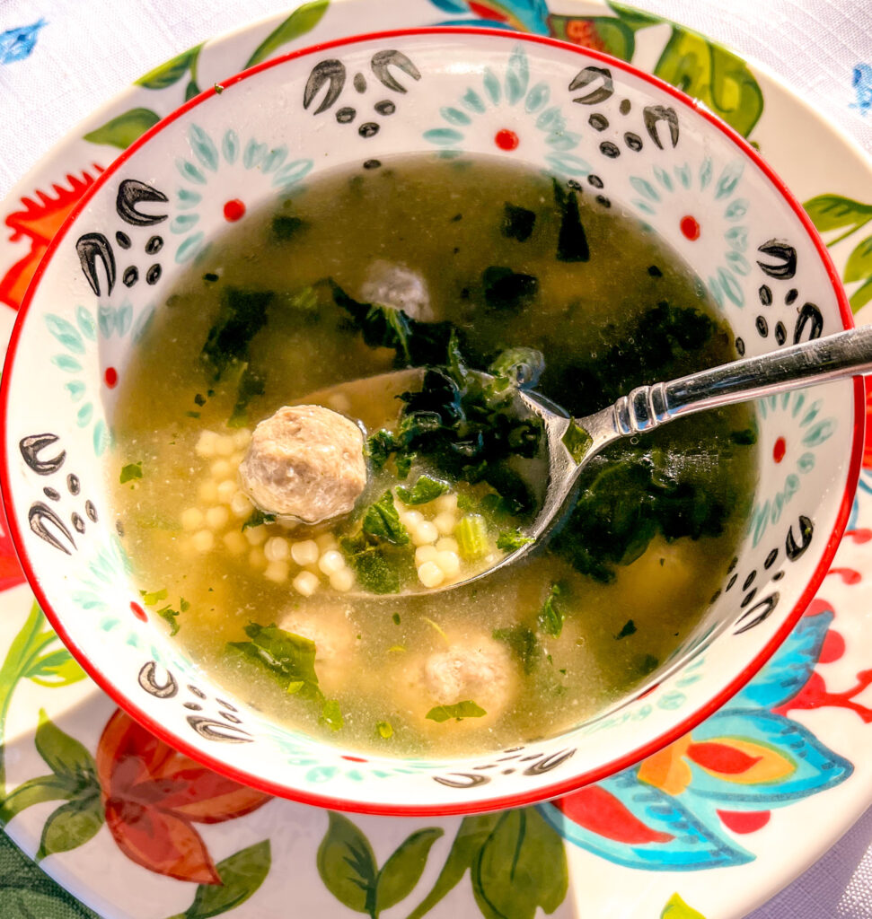 upclose shot of wedding soup in a colorful plate