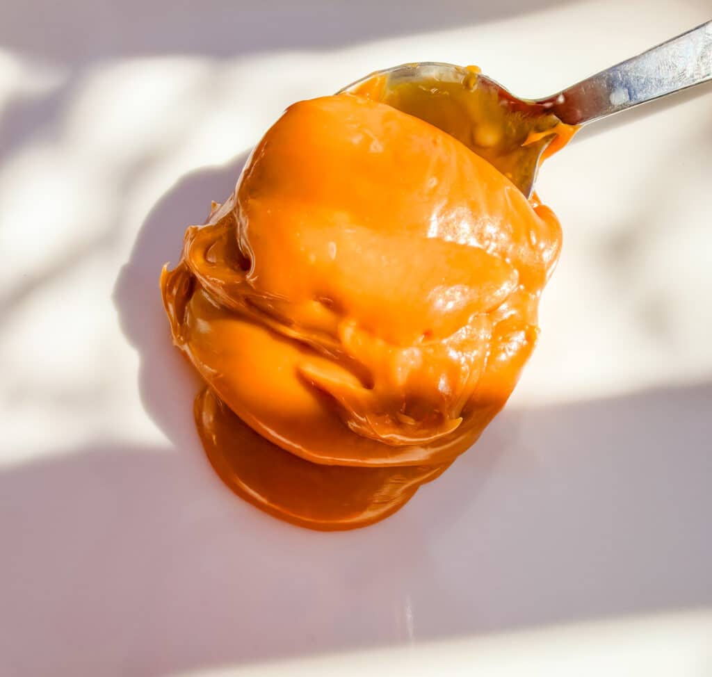 dulce de leche on a spoon on a white plate