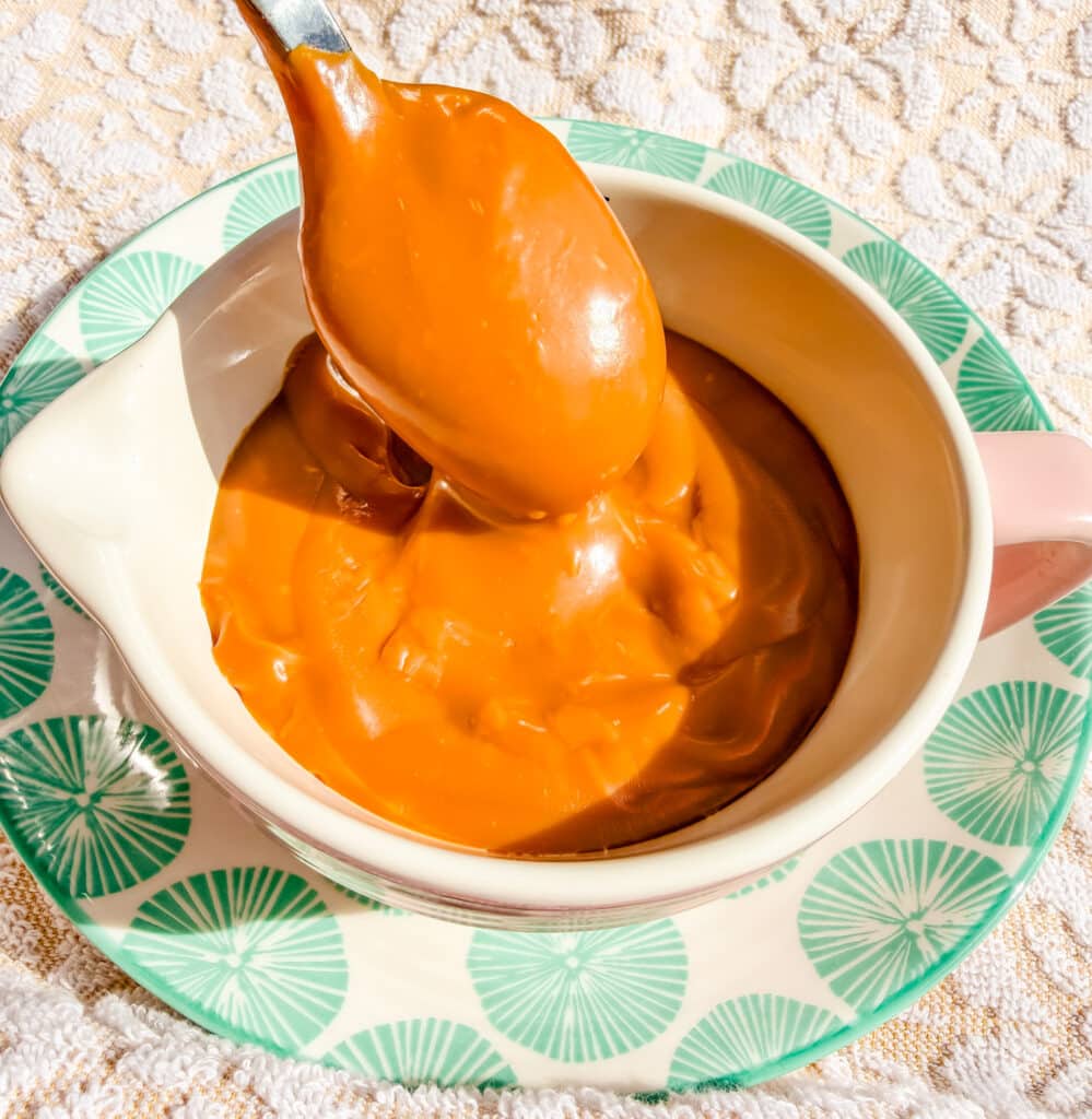 dulce de leche in small bowl being picked up by spoon