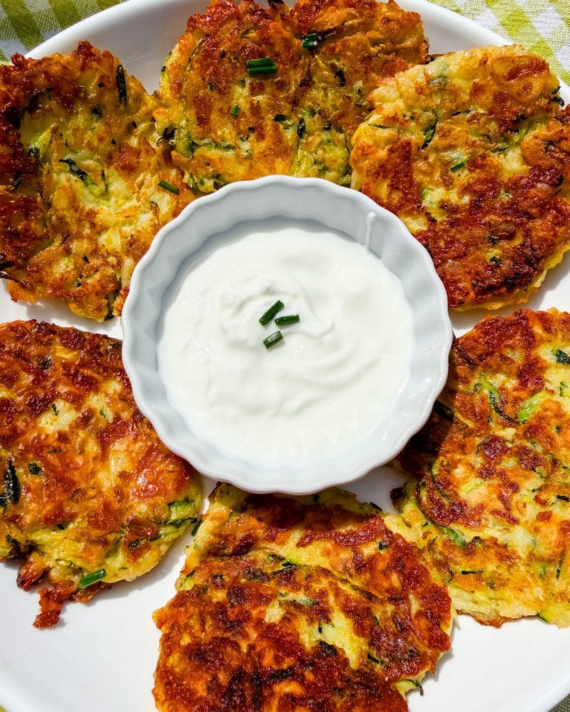 cheesy zucchini fritters view from the top served with sour cream