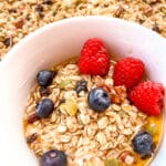 granola served in a white bowl with fruit.