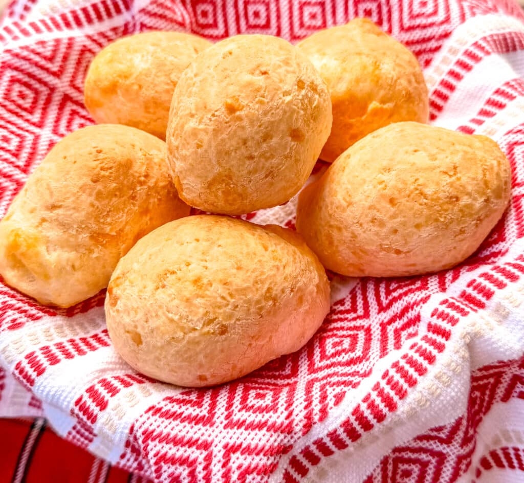 large pao de queijo brazilian cheese bread  on basket with red and white towel