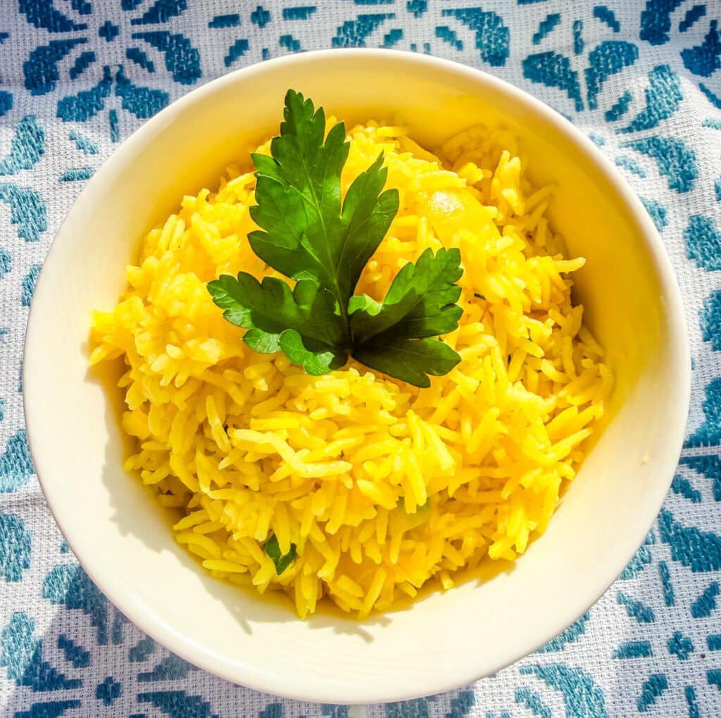 Mediterranean yellow rice served in a bowl, fluffy and vibrant with herbs