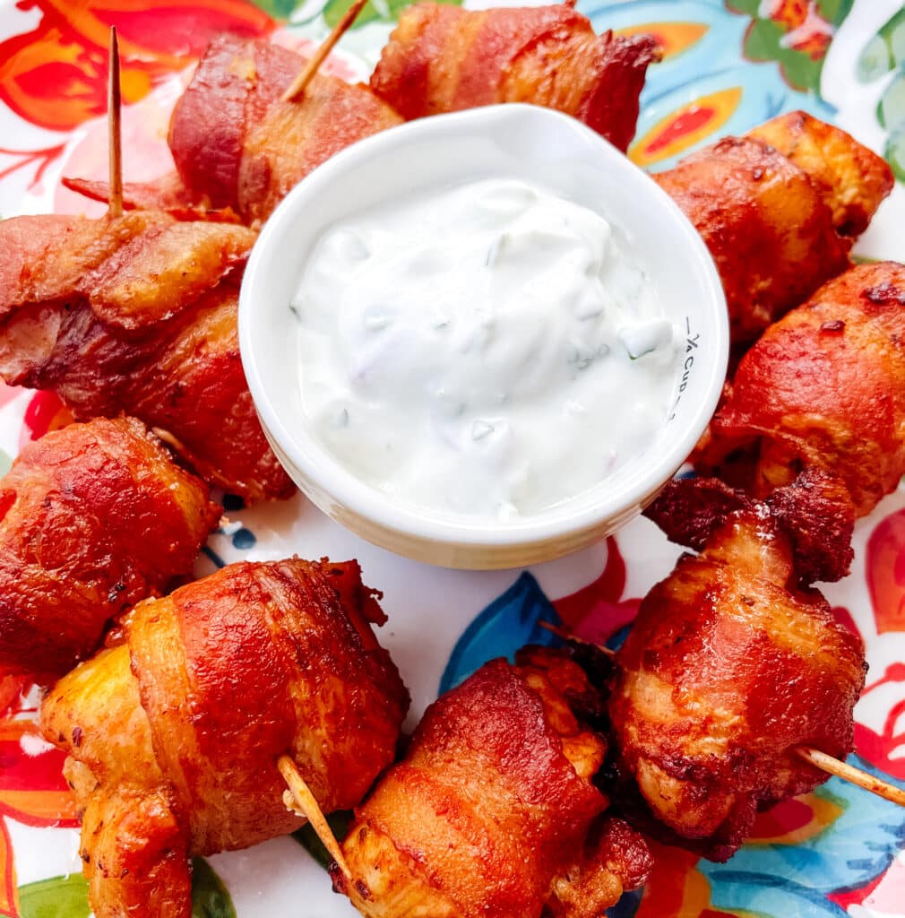 bacon wrapped chicken bites served with yogurt sauce on the side