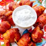 bacon wrapped chicken bites served with yogurt sauce on the side
