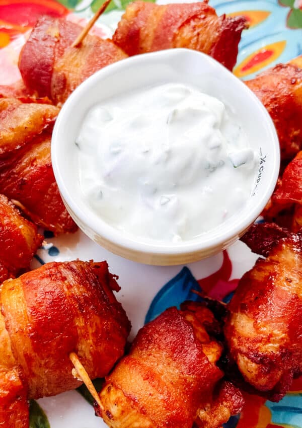 bacon wrapped chicken bites served with yogurt sauce on the side