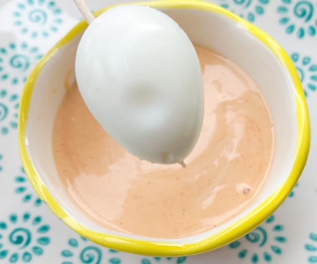 quail eggs/ovos de codorna on a toothpick in from of a little bowl with pink sauce or molho rose