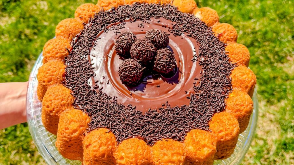 carrot cake with brigadeiro frosting decorated with sprinkles and brigadeiros. Bolo de cenoura com brigadeiro.