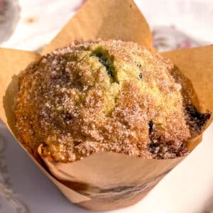 Fresh blueberry muffin wrapped in a tulip liner with golden, domed top