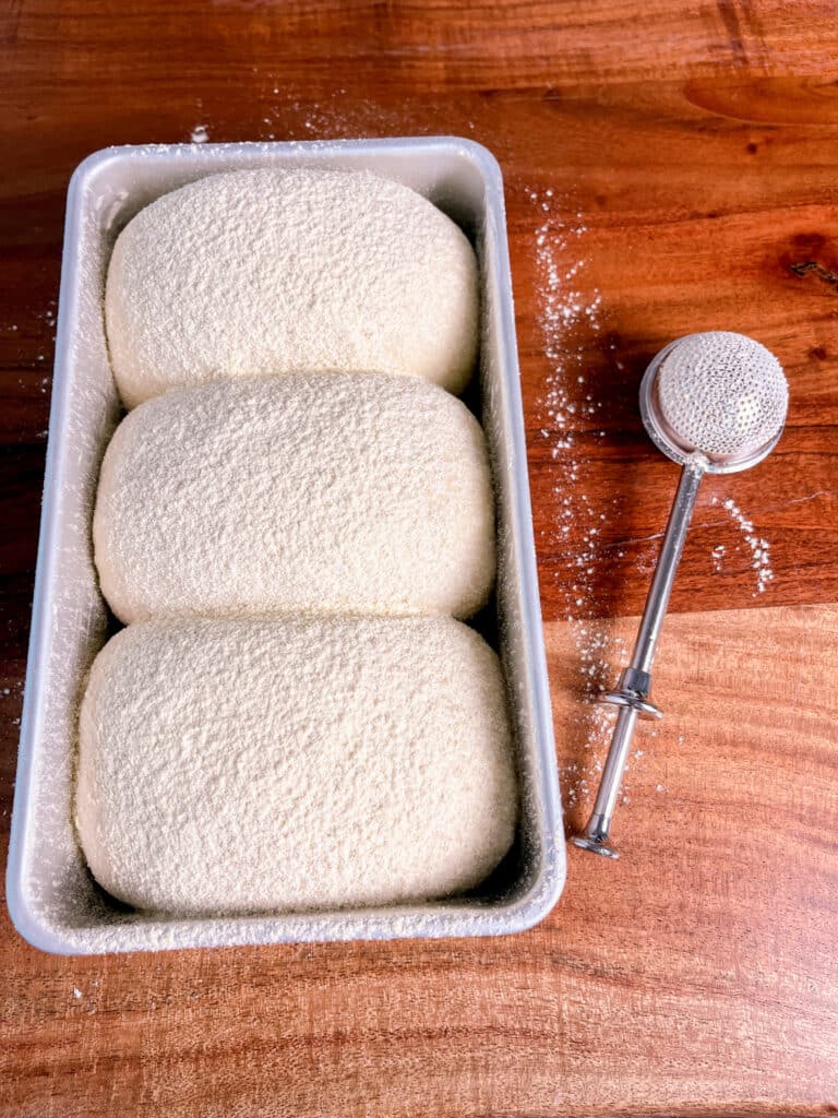 corn bread dough in a loaf pan dusted with cornmeal