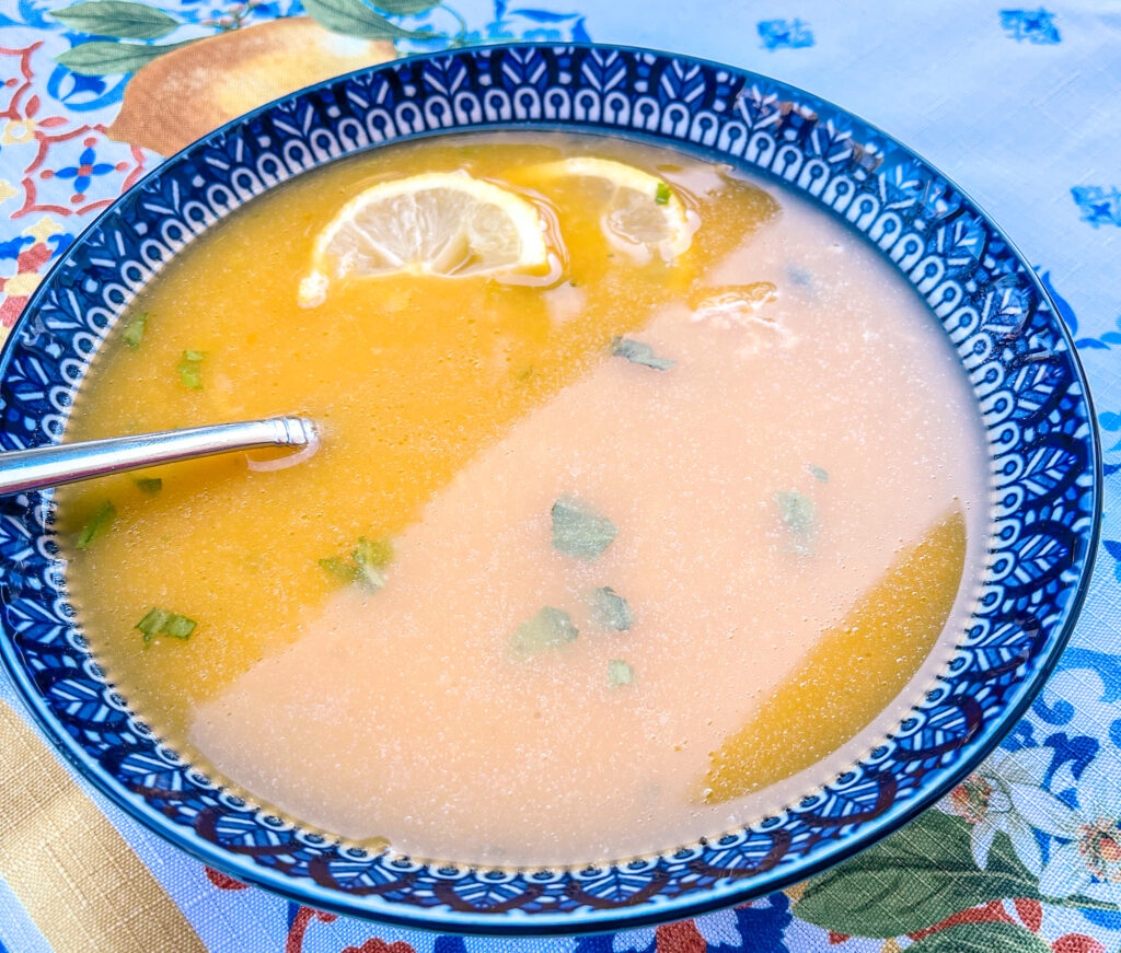 greek lemon chicken soup in a blue and white bowl