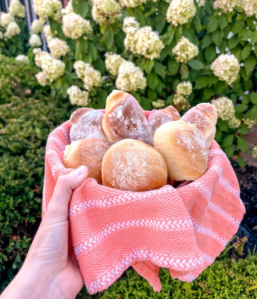 brazilian corn bread in an orange basket near hydrangea flours 