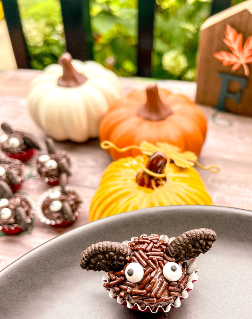 bat brigadeiros with pumpkins are more bats in the background