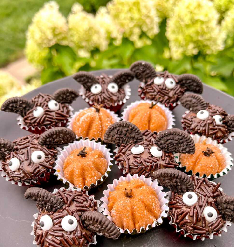 bat brigadeiros and pumpkin brigadeiros with hydrangeas in the background