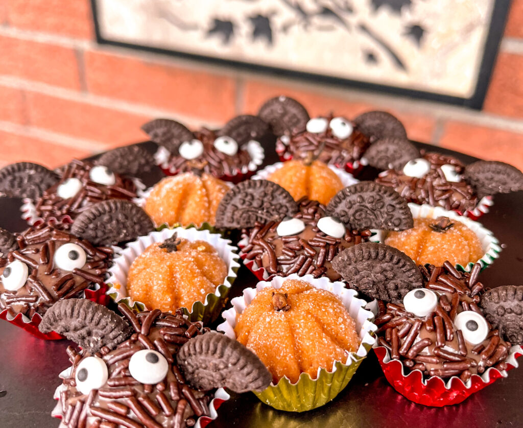 bat brigadeiros with pumpkin brigadeiros on a black plate
