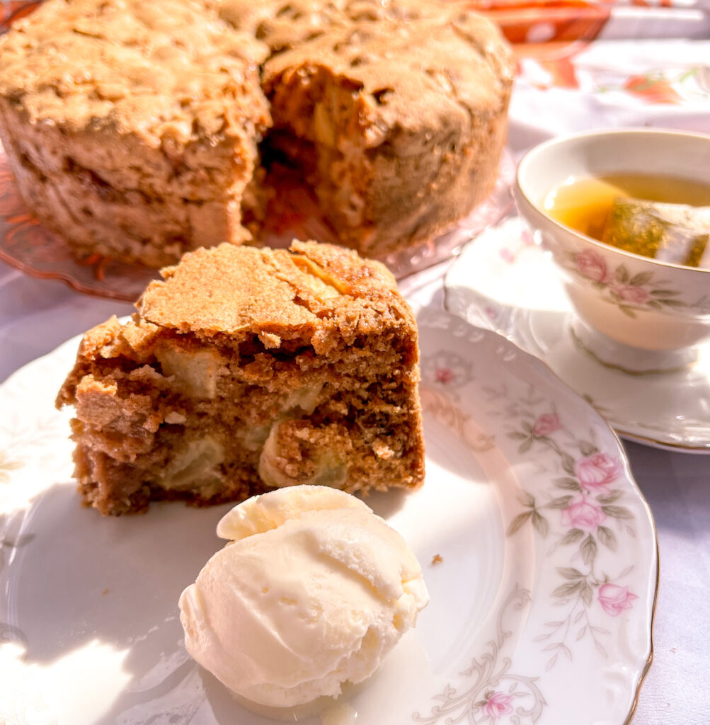 Apple cake served with ice cream with cake and tea on the background