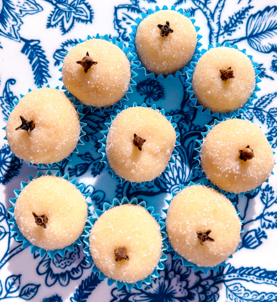white brigadeiros in blue paper cups on a blue and white plate top view