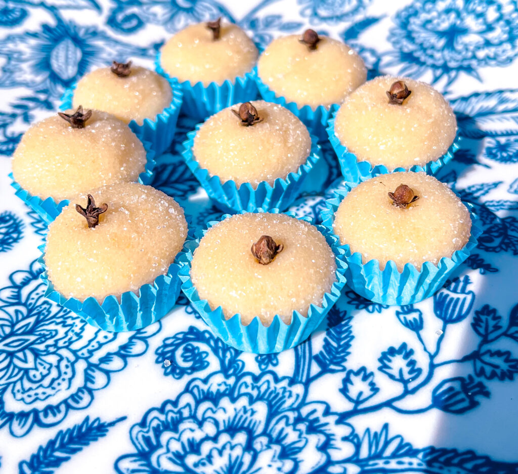 white brigadeiros in blue paper cups on a blue and white plate