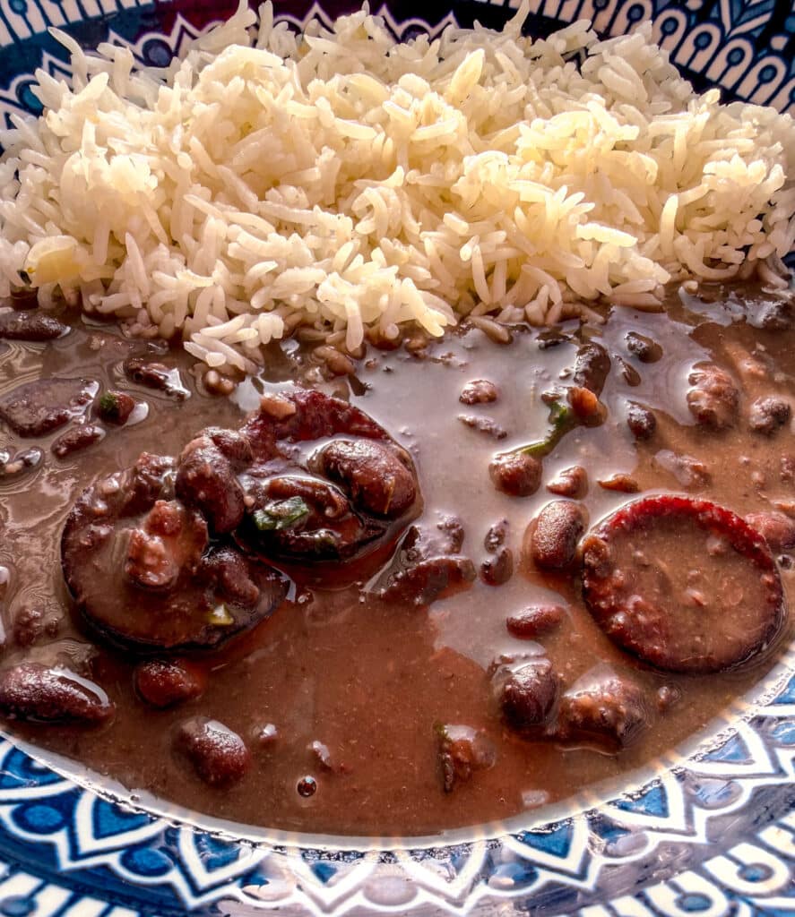 brazilian black beans with bacon in a colorful blue plate with rice