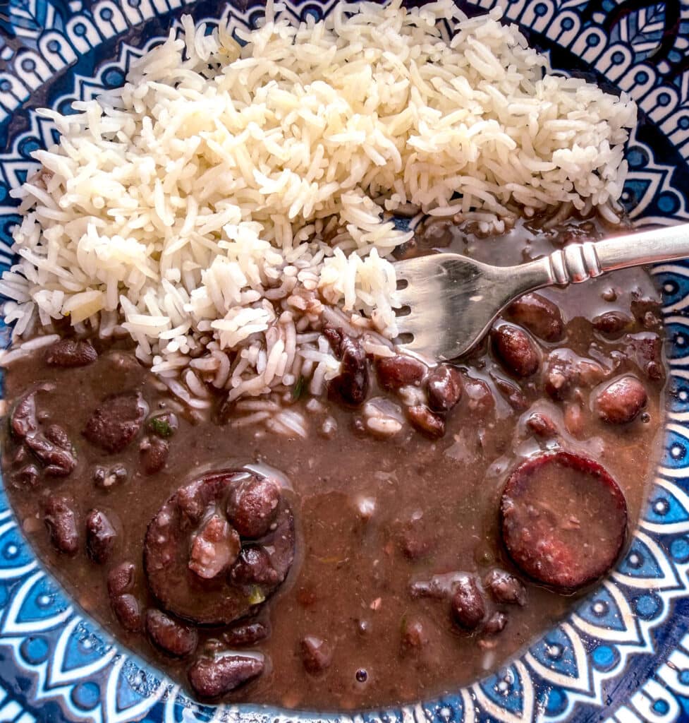 colorful blue plate with brazilian black beans a fork and rice