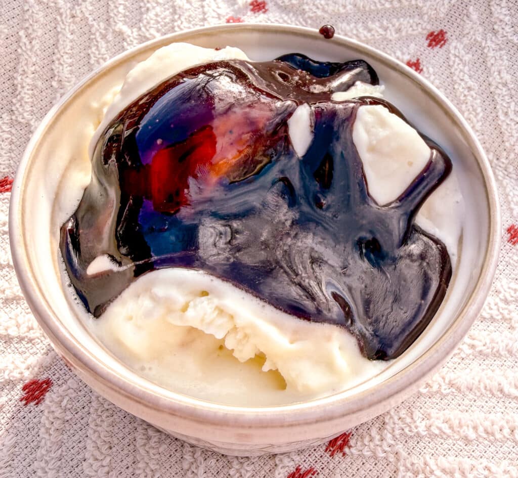 chocolate syrup on vanilla ice cream in a ramekin