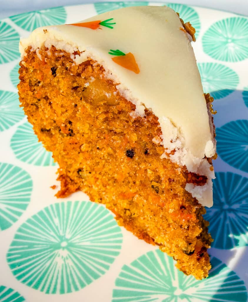 slice of carrot cake with porcelain glaze side view on teal plate