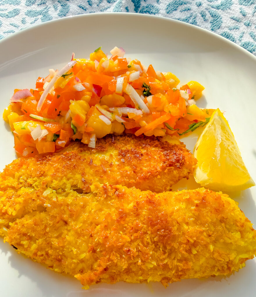 Coconut crusted tilapia with crispy golden coating served with fresh mango salsa