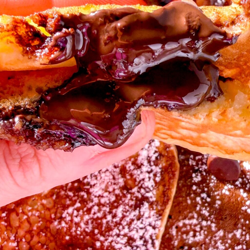 up close shot of chocolate oozing out of a banana pancake