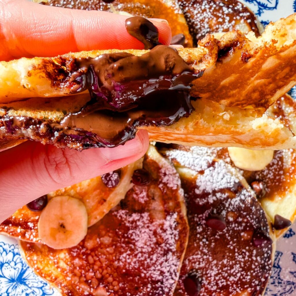 up close shot of chocolate oozing out of a banana pancake
