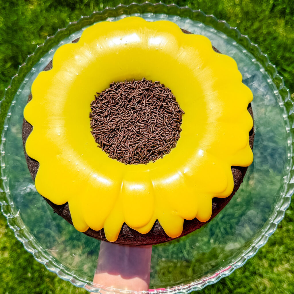 Chocolate cake decorated like a sunflower with yellow brigadeiro frosting and chocolate sprinkles