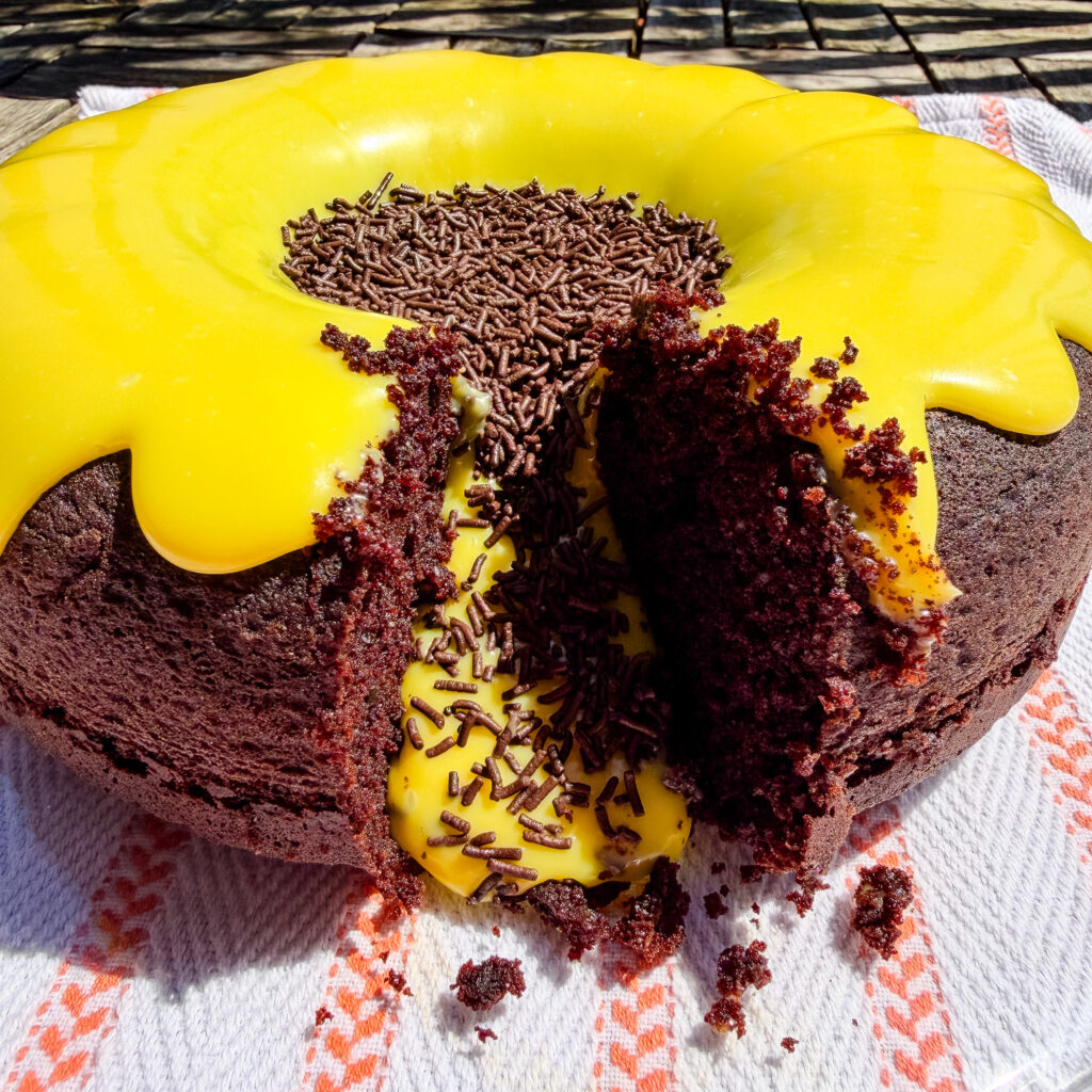 Glossy white chocolate brigadeiro frosting spread oozing out of chocolate cake