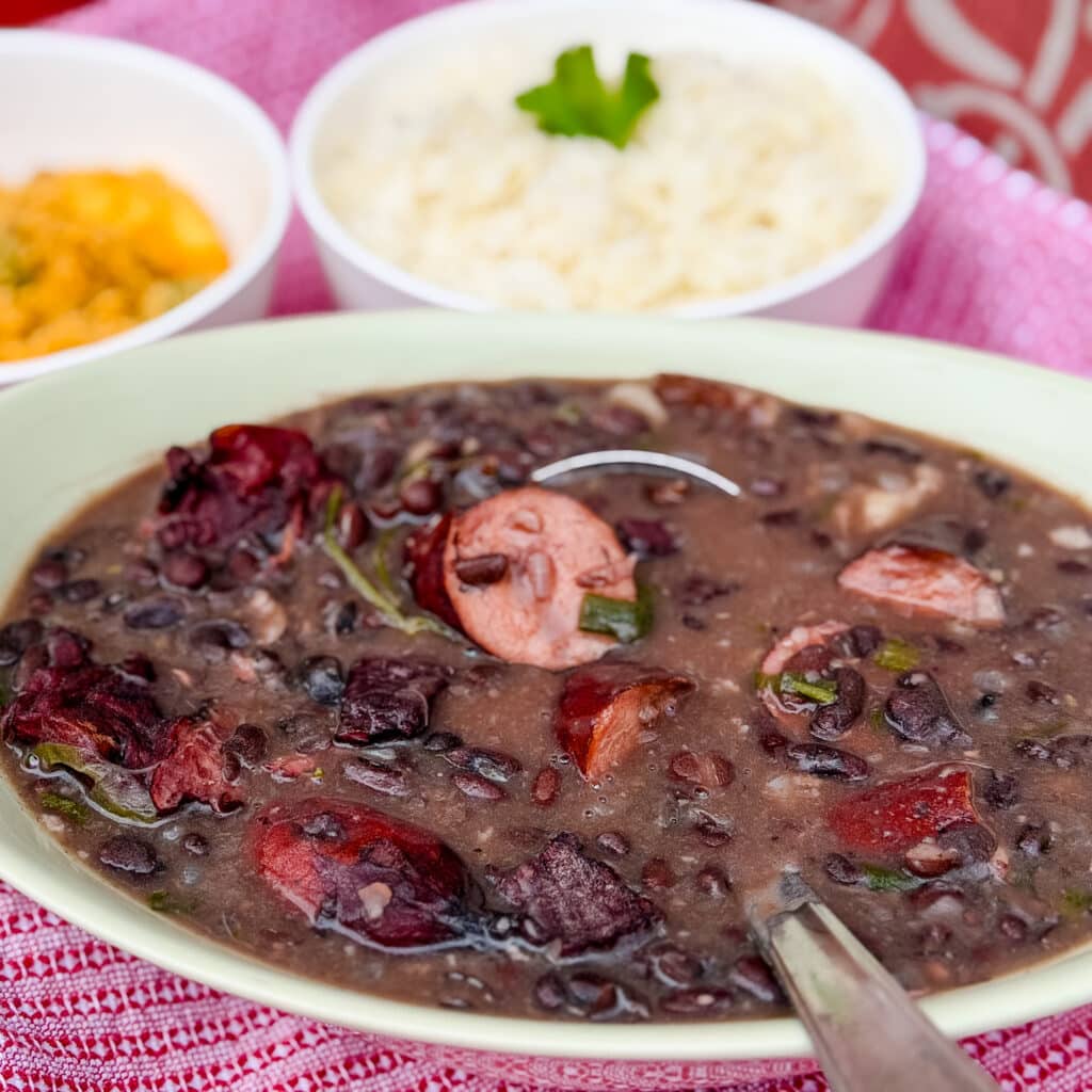 Brazilian feijoada served alongside white rice and farofa