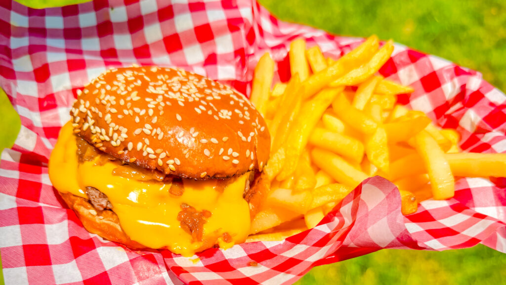 cheddar mcmelt served with fries on red and white checkered paper